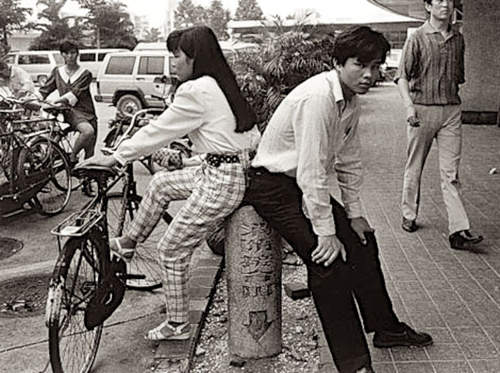 一张生活老照片,1988年的深圳街头,一对男女骑自行车累了,两人正在