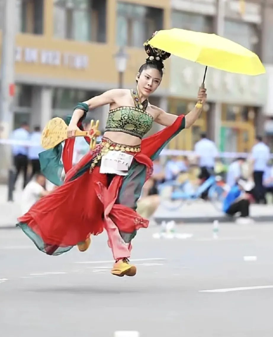 她仿佛是敦煌壁画中飞天女神走入现实,一手持琵琶,一手持伞,身姿轻盈