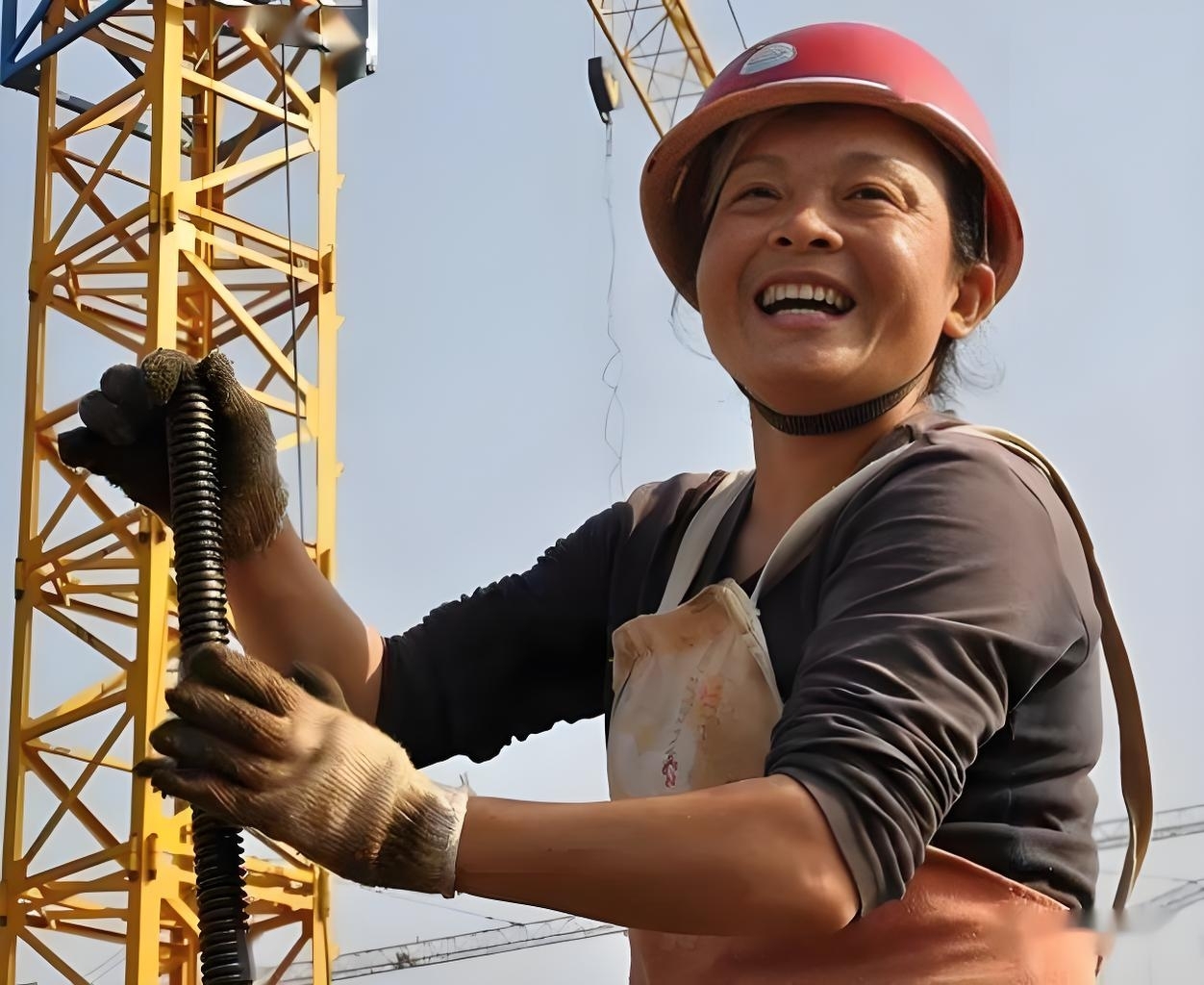 这位大姐笑的那么甜美爽朗,头戴安全帽手上戴着油腻的手套,身穿工作服