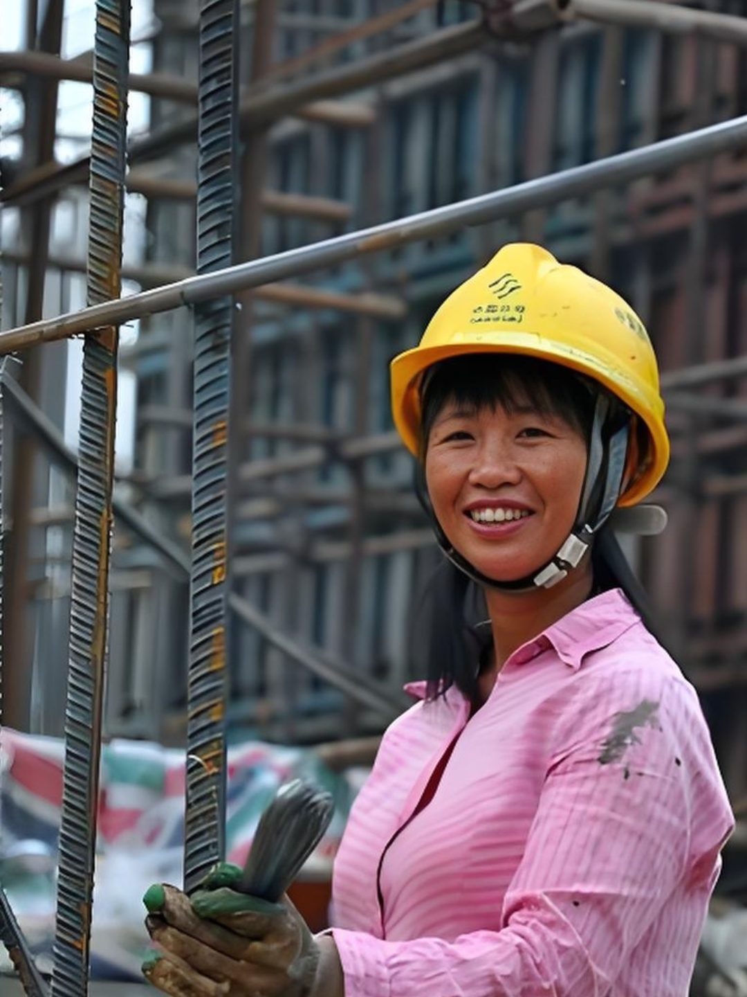 工地上的小姐姐笑容满面,安全帽和手套是她进入施工