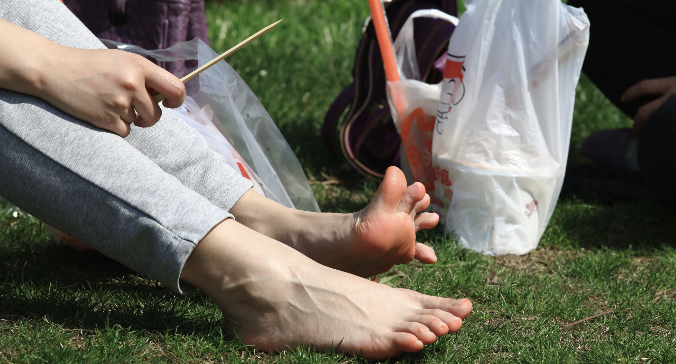 草地上喝水的美女,脚底有些发红啊