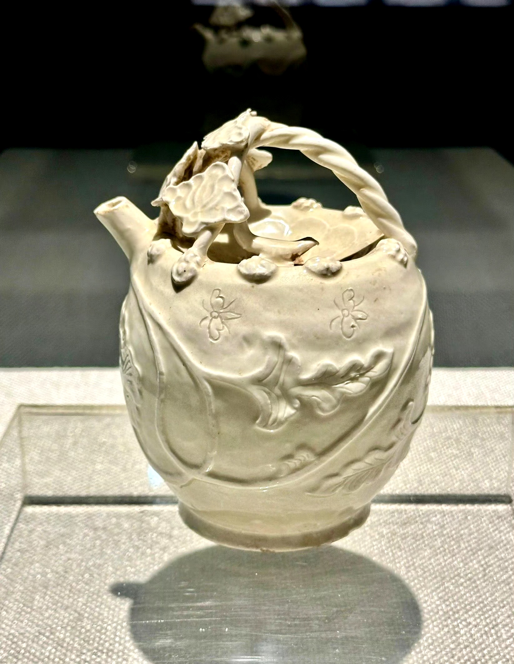 出土于辽阳南林子辽墓的白釉雕牡丹花提梁注壶.现收藏于辽阳市博物馆