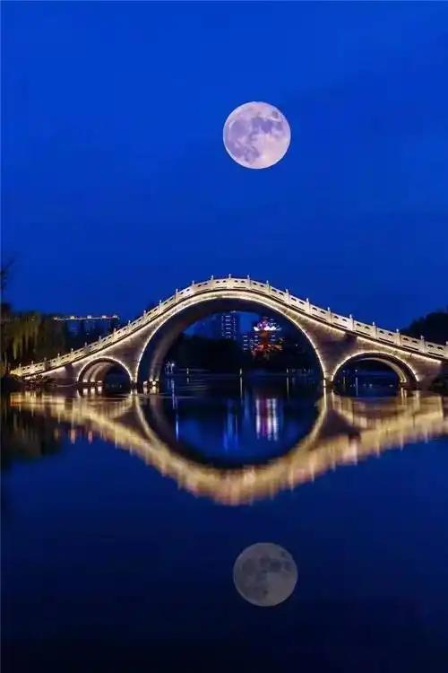 桥头灯火朦胧处, 浪涌悠悠漾岸旁