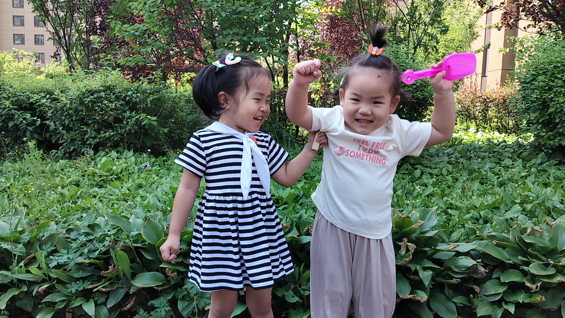两个小女孩手拉手,欢乐地在小区里奔跑,自由地像风一样.