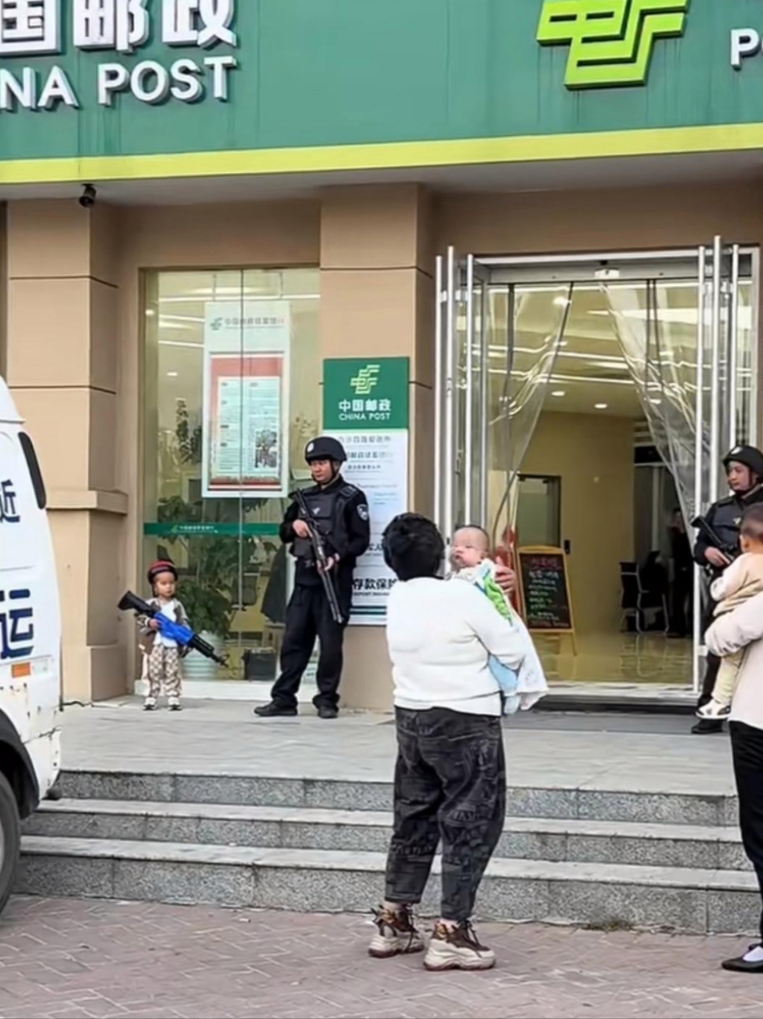 这小孩真厉害,站着银行门口手还拿着枪