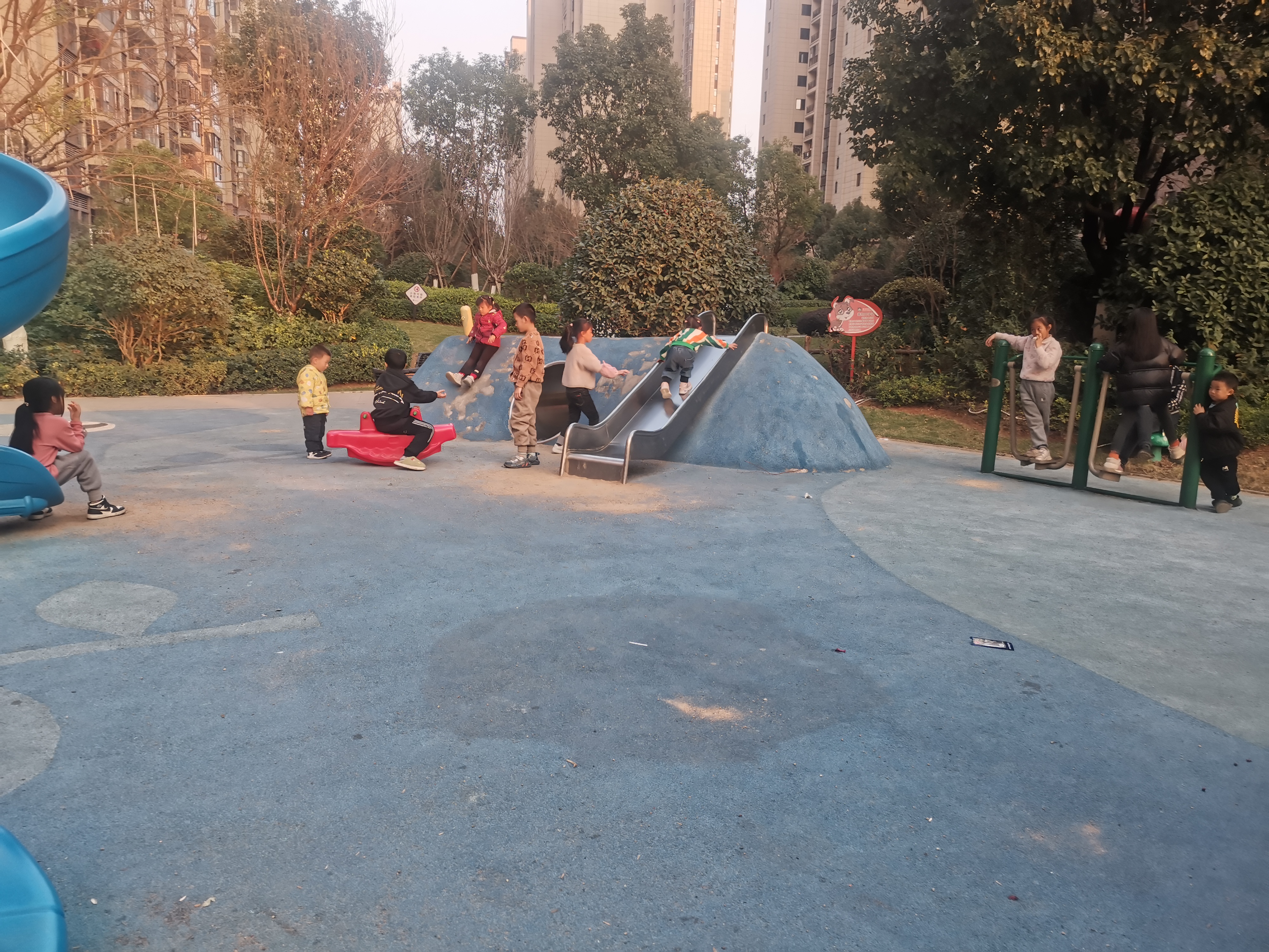 在阳光明媚的午后,公园里的小朋友们穿着色彩斑斓的衣服,尽情玩耍.