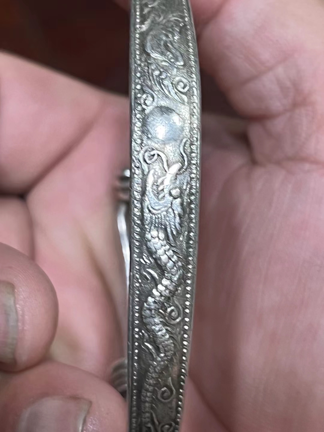 那是一款饱含岁月沧桑的老龙凤呈祥银手镯,犹如一段古老的传说,在时光