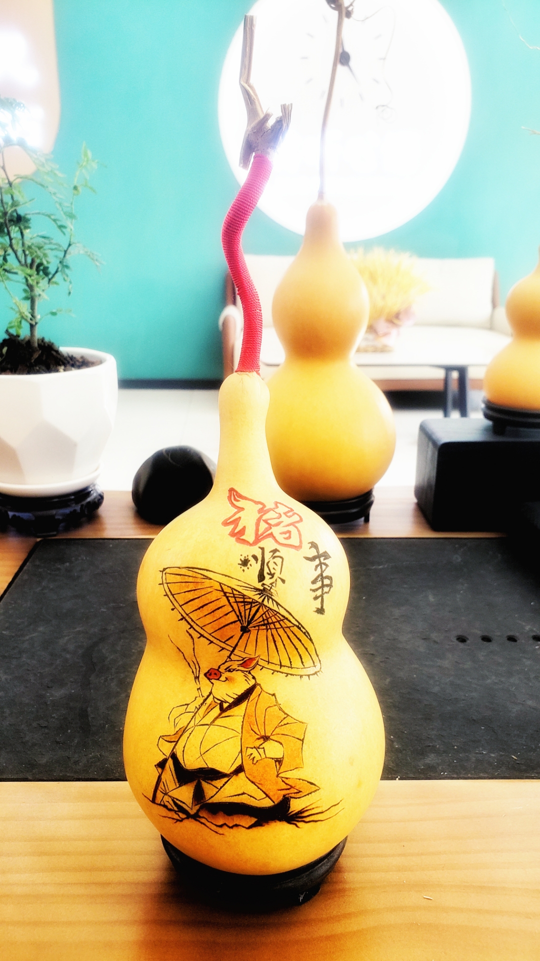 这个葫芦呈温暖的黄色,上面绘有黑色和红色的精美图案,仿佛诉说着古老