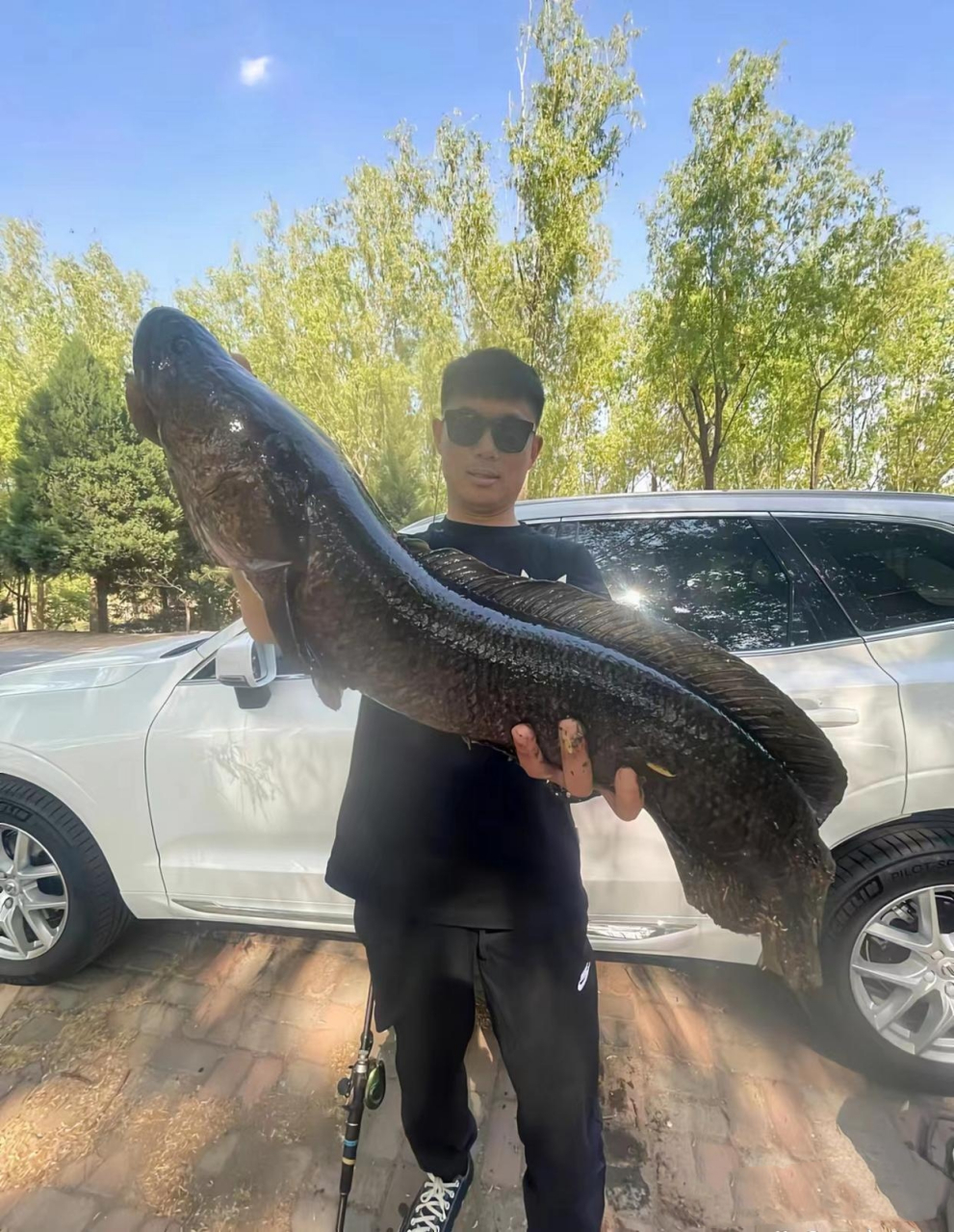 这位兄弟今天钓到了一条大黑鱼,看上去估计有几十斤重的样子,那个兴奋