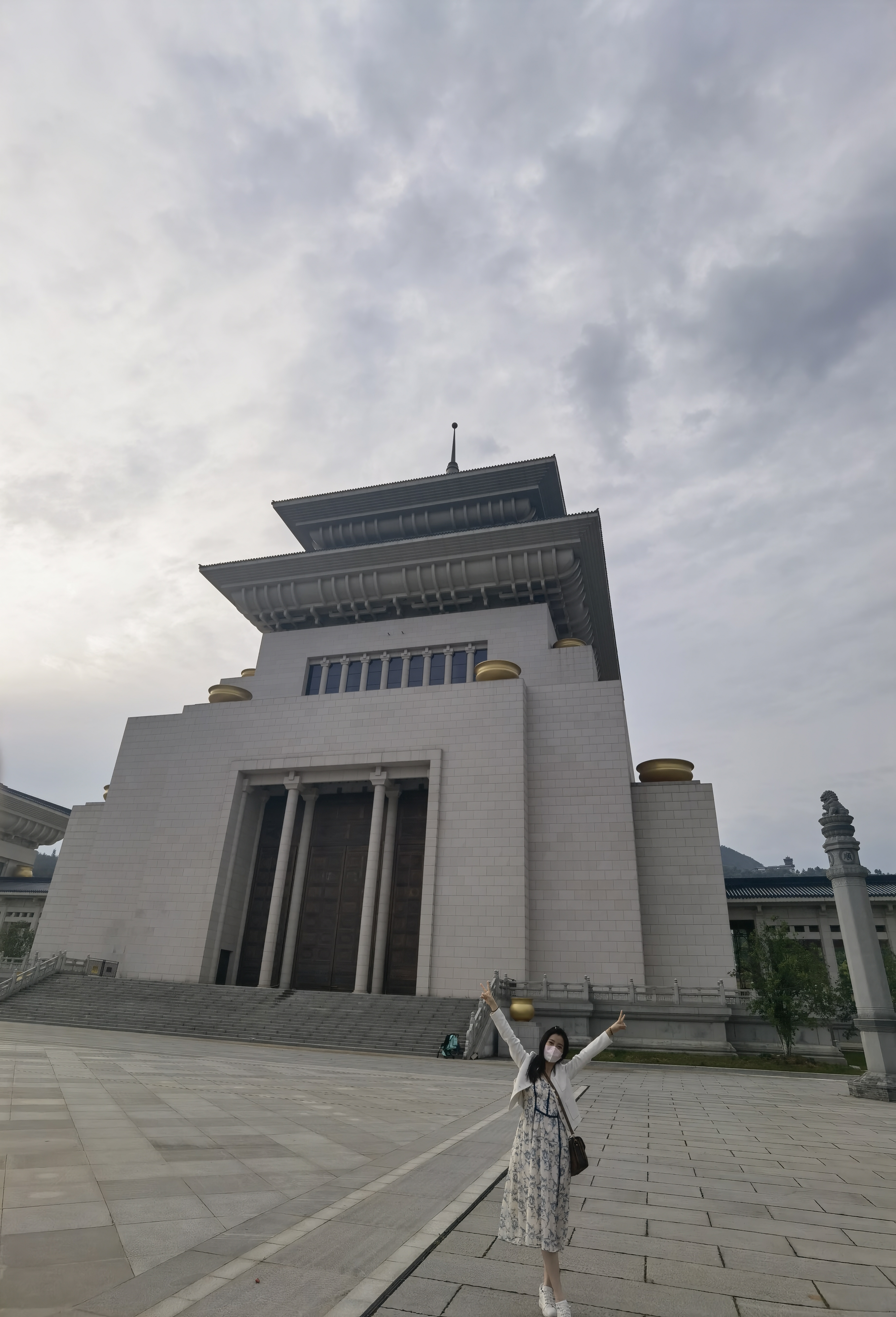 那位女士,穿着简约而不简单的白裙,与背后的宏伟建筑形成鲜明对比