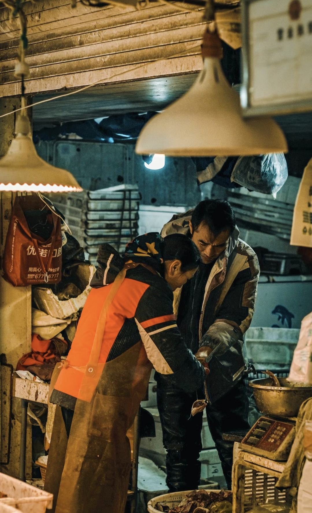 菜市场是生活的剧场.摊主们忙碌不停,或整理水产,或清点钱款