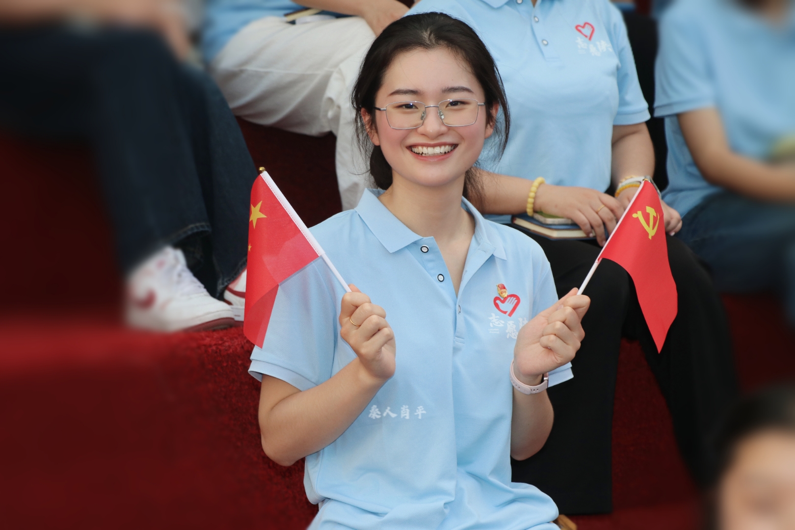 在西安培华学院的体育场场,西部计划志愿者们手里挥动着五星红旗与