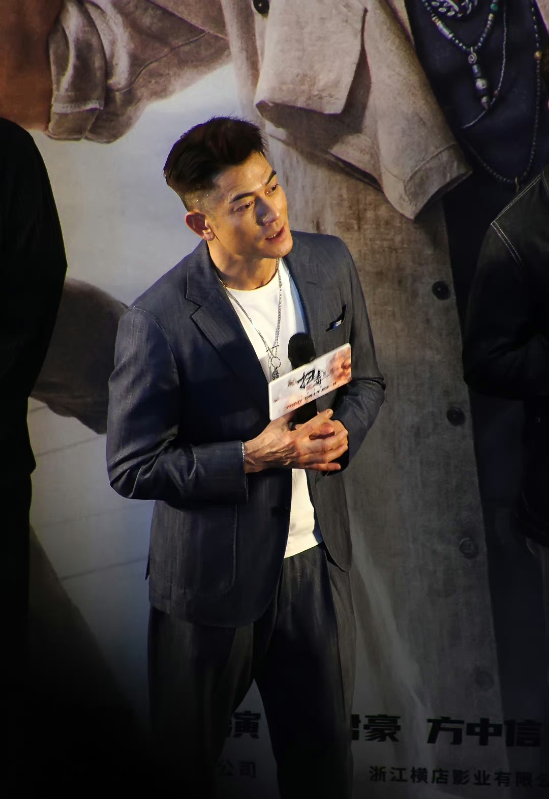 郭富城这身深靛蓝色单排两扣平驳领贴袋西装内搭白色t恤的穿搭看起来