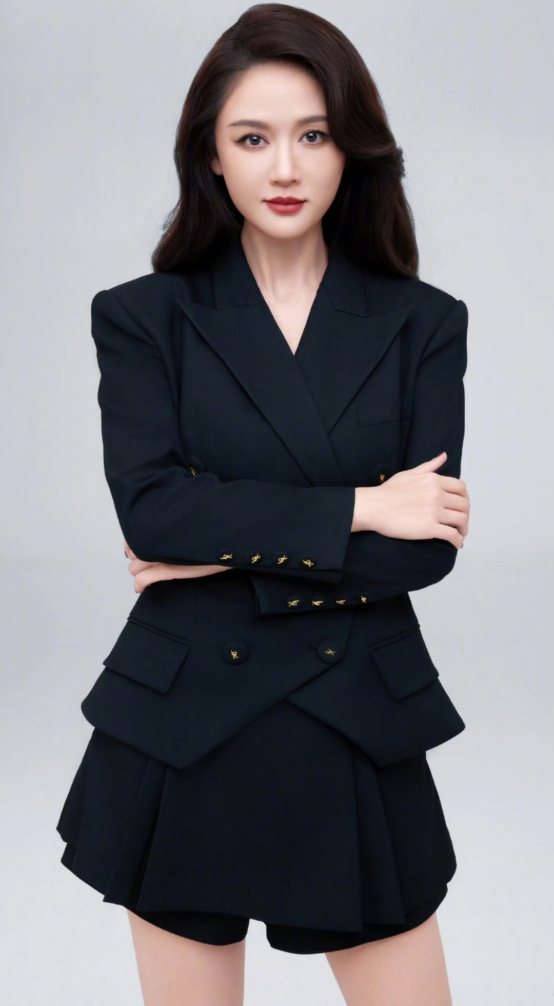 陈乔恩深棕色长发,穿上黑色双排扣西装外套黑色百褶短裙,双臂时而交叉
