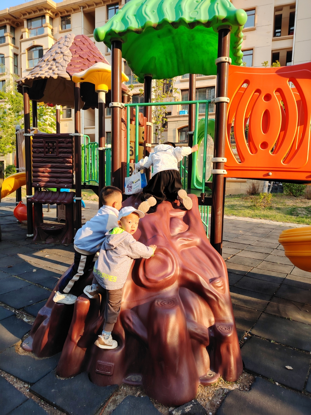 孩童们追逐嬉戏于滑梯假山间,银铃般的欢笑声在暮色