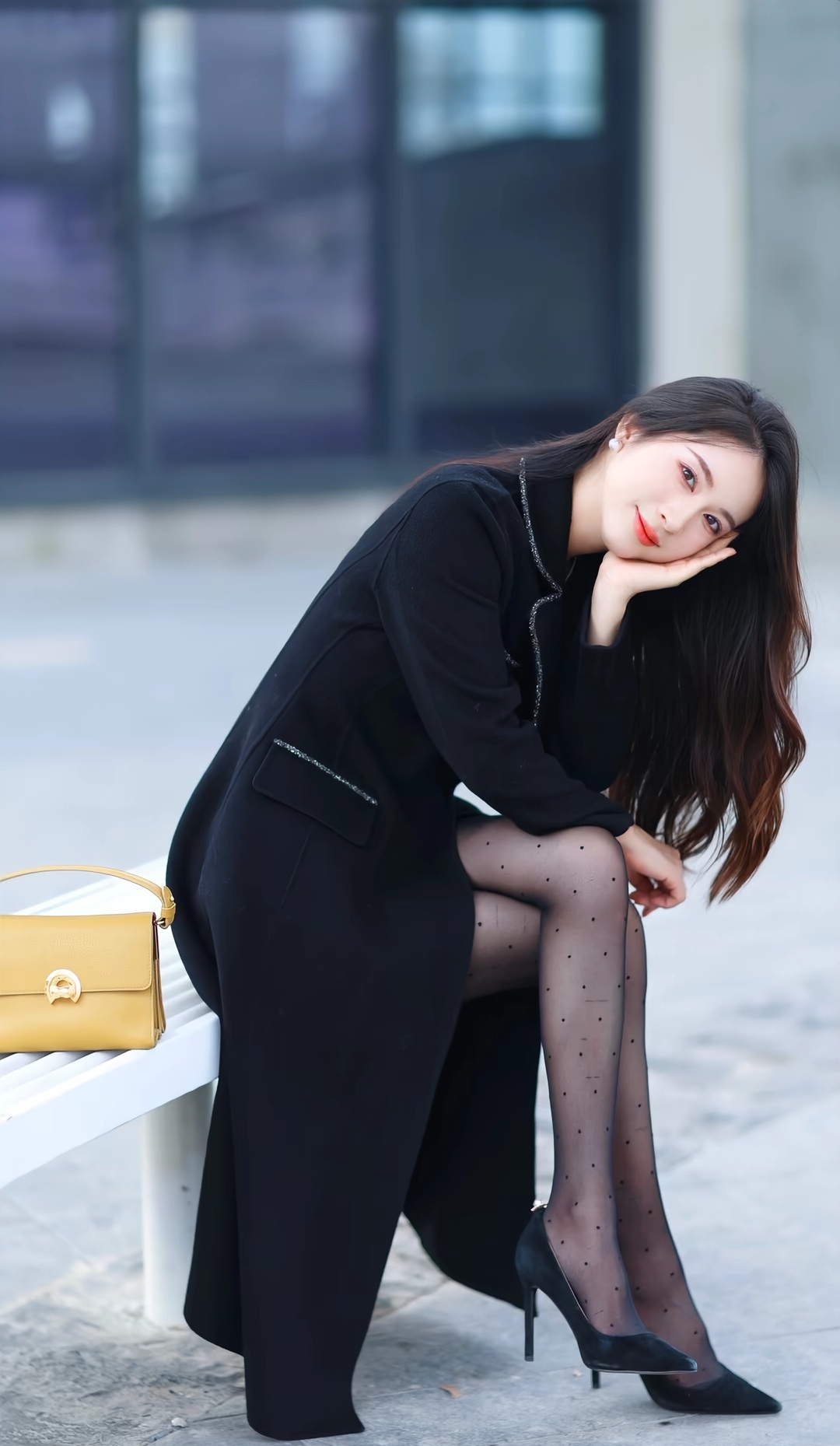 在温暖的午后,阳光洒在街头,一位优雅的美女坐在长椅上,黑裙丝滑,红唇