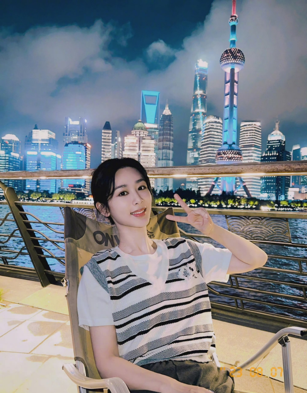 杨紫穿t恤在东方明珠塔下,玩剪刀手拍照,特别可爱.
