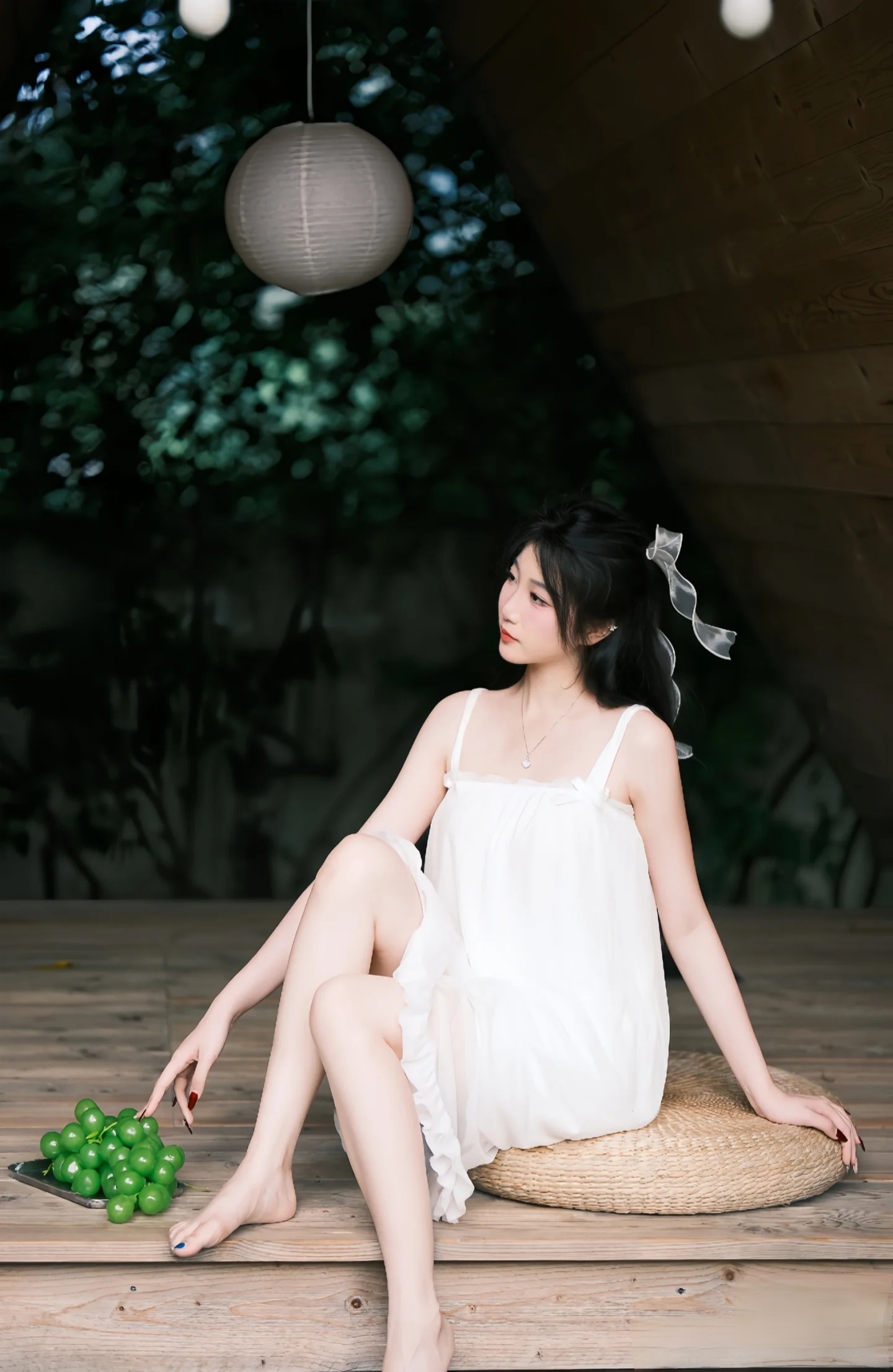 夏日微风,绿叶成荫,女孩轻倚木栏,手中握着一串鲜绿的葡萄,静谧时光里