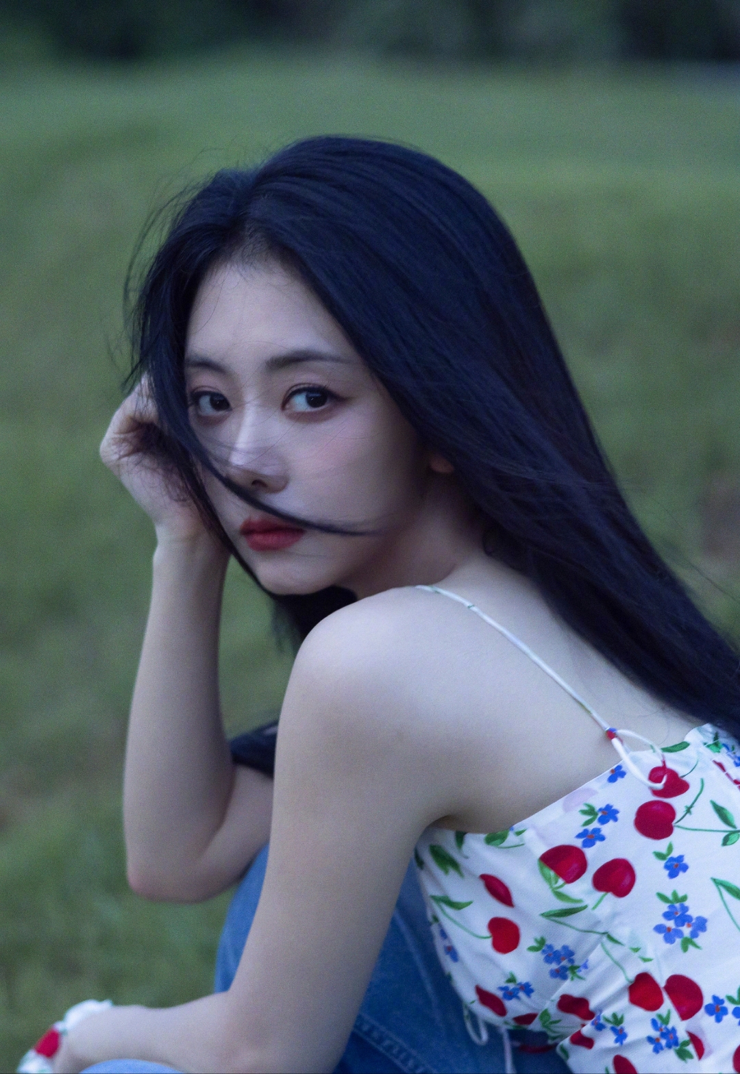 谭松韵坐在草地上,风吹起她的长发,她轻抚发丝,眼神中带着一丝忧郁