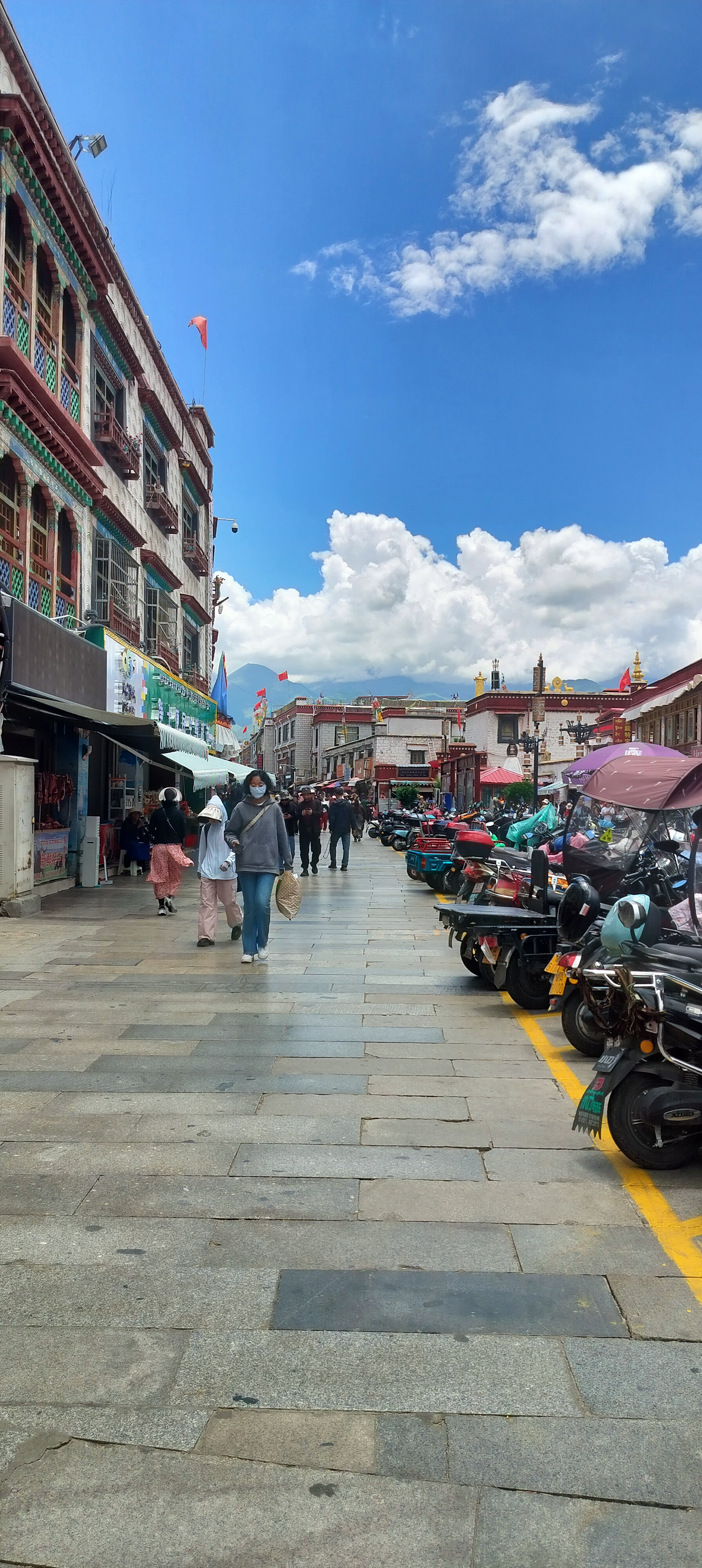 在拉萨的小昭寺街道上,藏式房屋错落有致地排列在石板路上,散发着浓厚