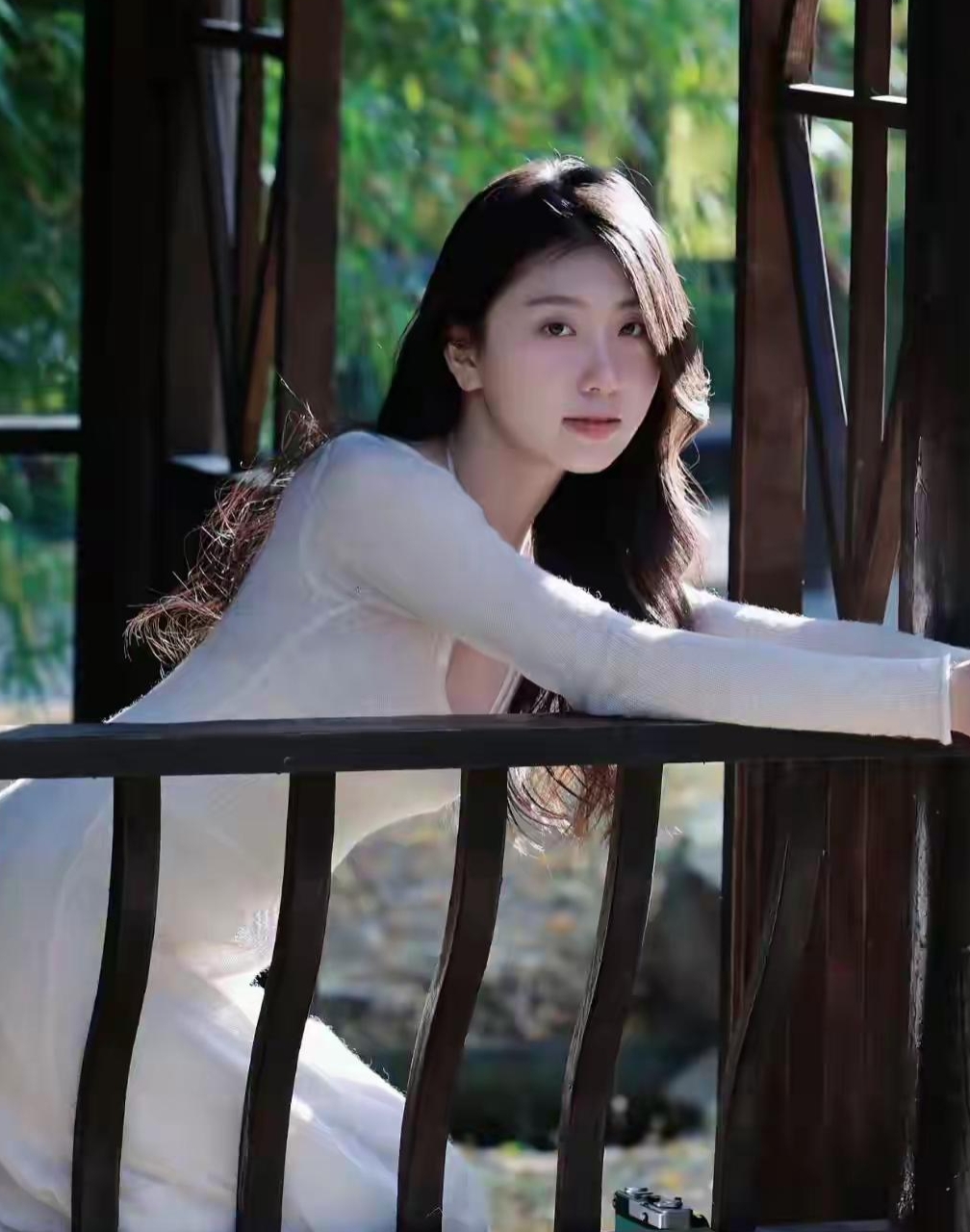 在翠绿的竹林深闺,一位白衣少女静立其中,她的存在仿佛是一首诗,一幅