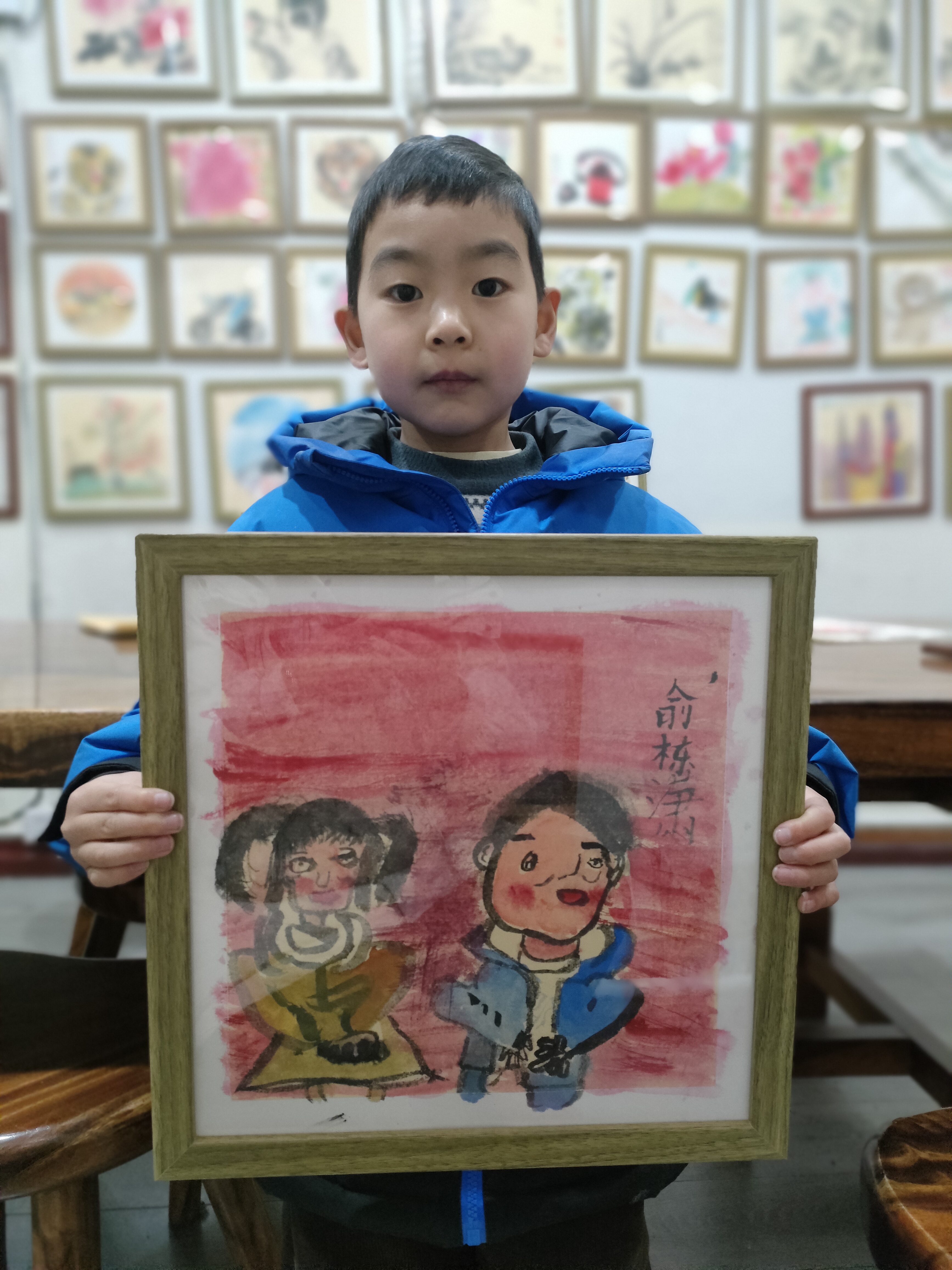 书法国画小达人上线  身穿蓝色外套的男孩,正沉浸在书写的世界中.