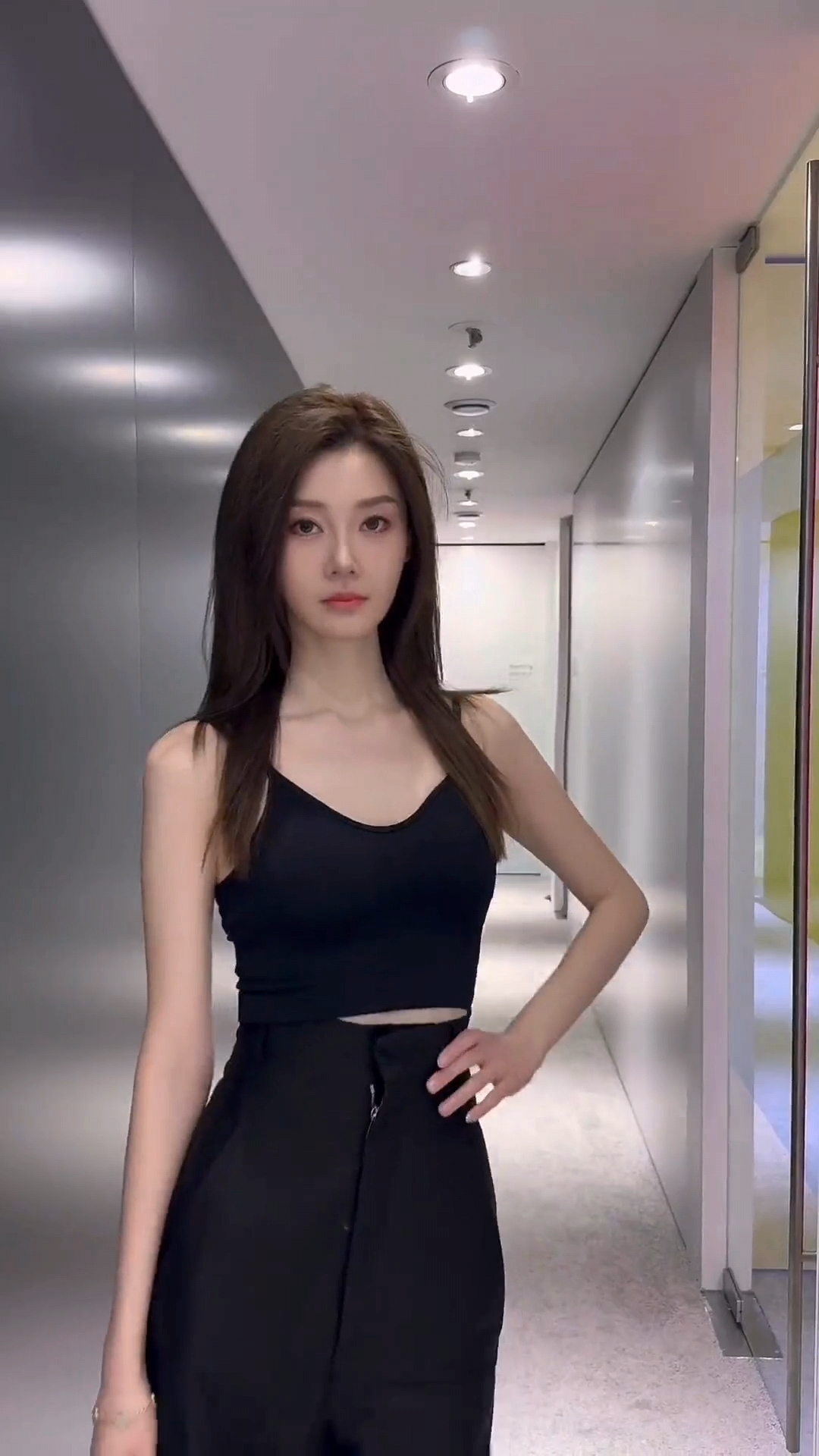 车模张苪尔今天穿了件小黑裙,走在光影交错的走廊里,随手一拍就是大片