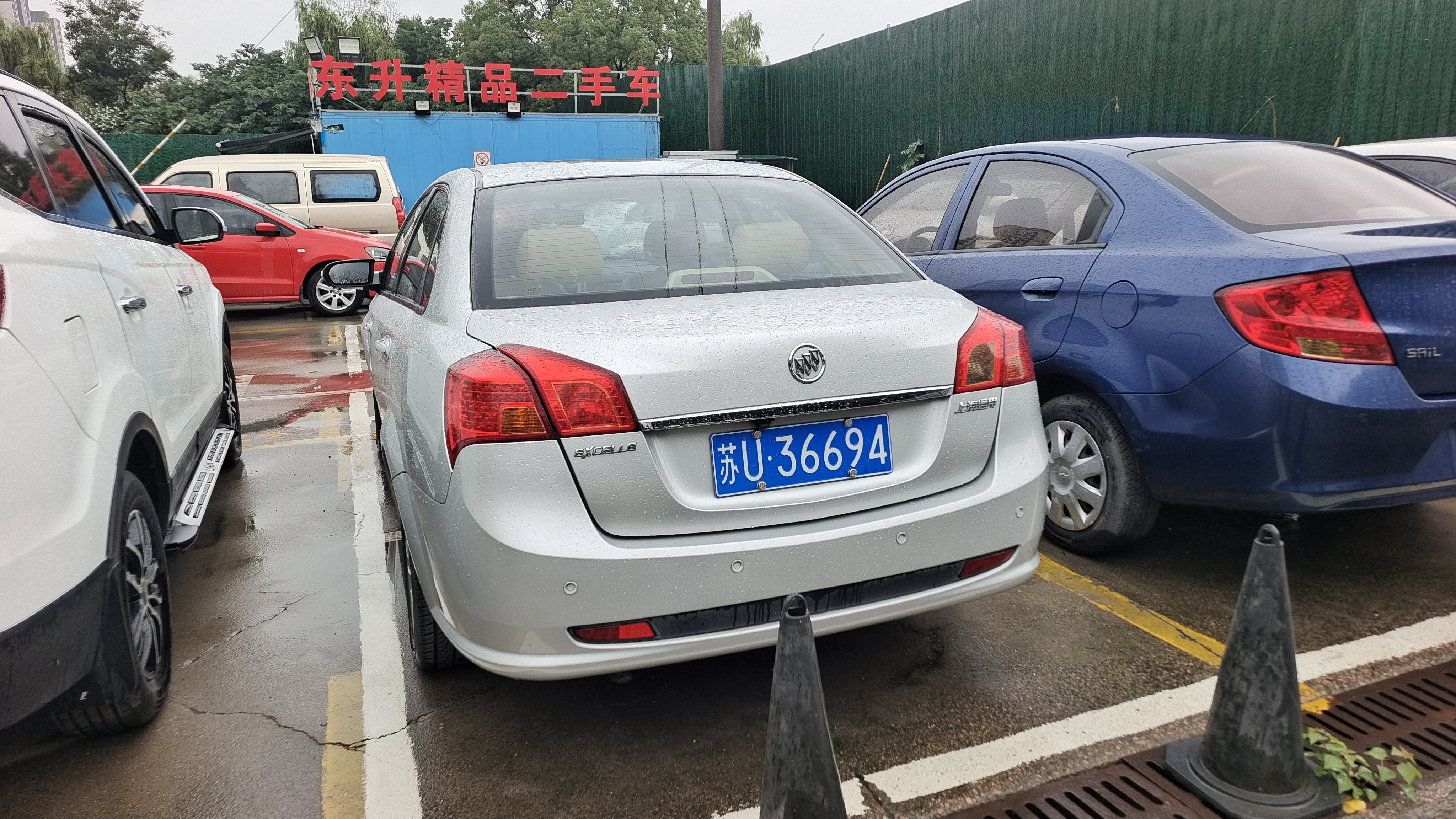 雨天停车场,三车一排巧遇,苏u36694小别克,旁边是哪位?