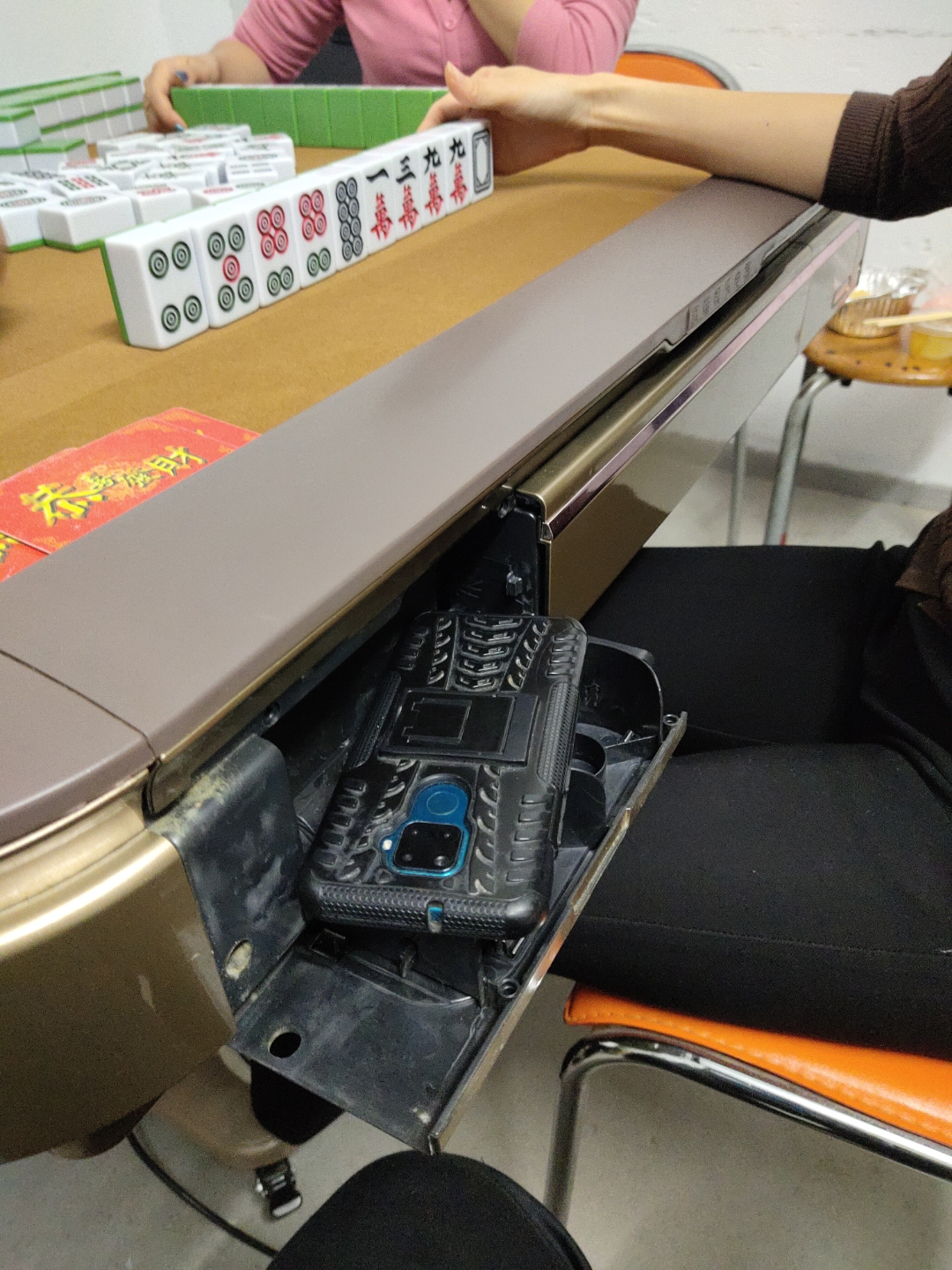 桌面上,麻将牌与手机充电宝相映成趣.