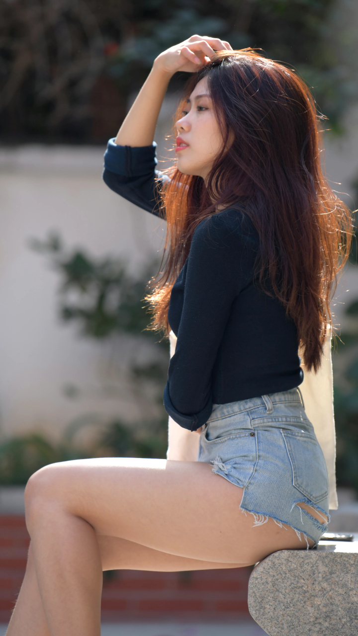 河畔倩影,一袭黑衣,牛仔短裤,悠然自得,手机在手,世界我有.