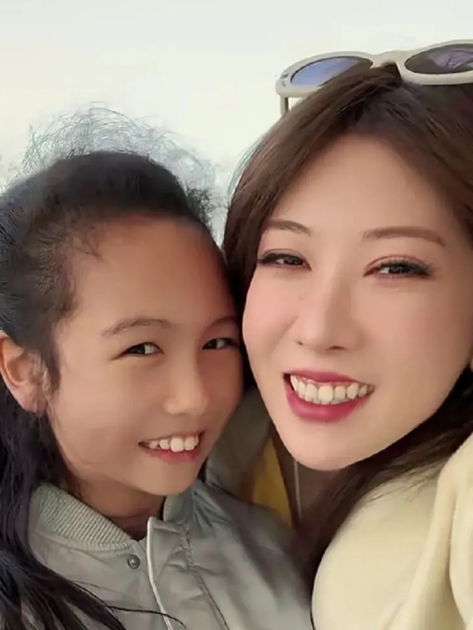 母女两个人海滩度假,女儿给妈妈拍摄各种照片.