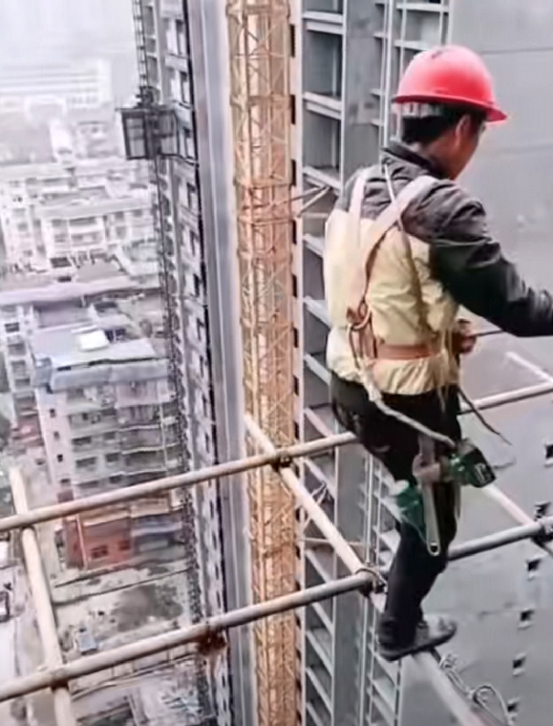 城市高处,脚手架上,一位建筑工人专注地进行着高空作业.