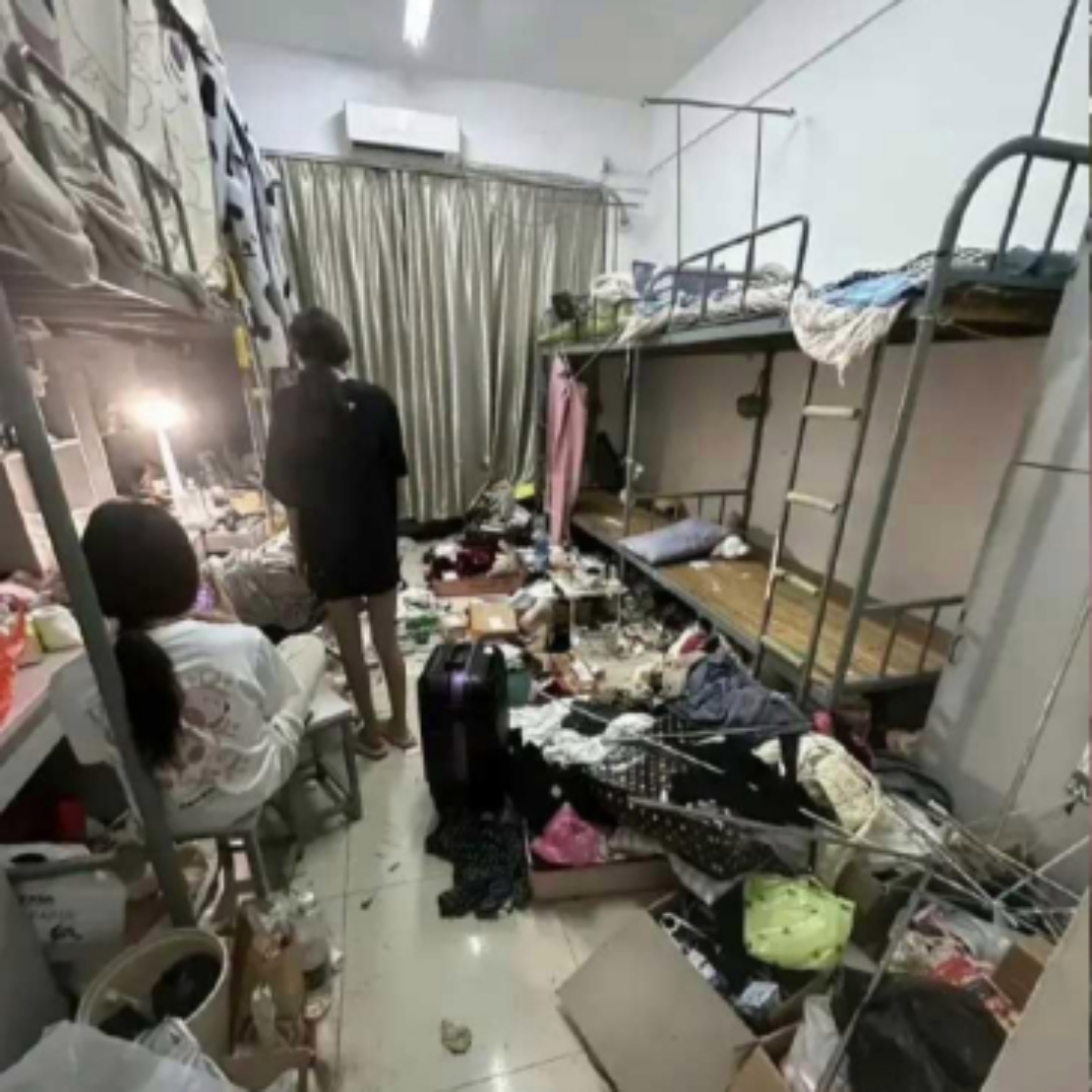 图片中的宿舍仿佛被杂物淹没,各类物品杂乱无章地堆积着,几乎没有下脚