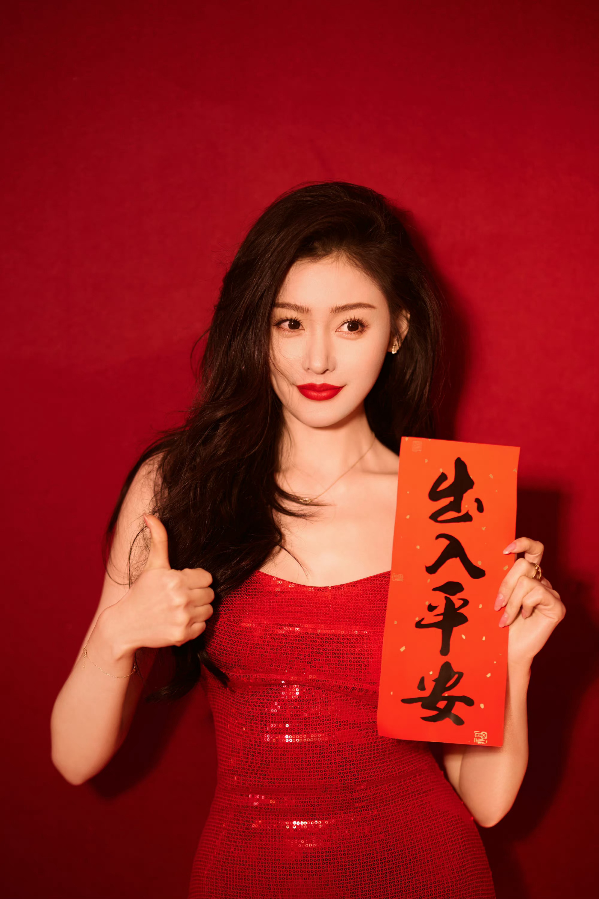 张天爱的红色春联之旅,一袭红裙,手持吉大春新春联,红唇红衣,展现出