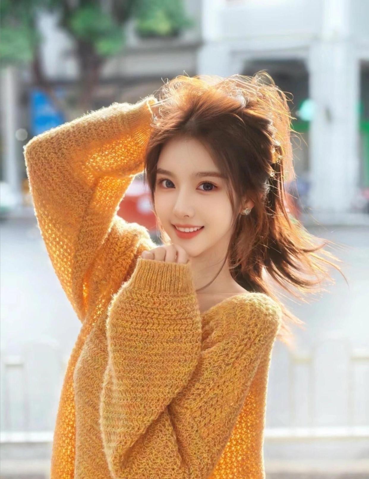 秋日暖阳下,街头捕捉到的一抹微笑,穿橙色毛衣的女孩