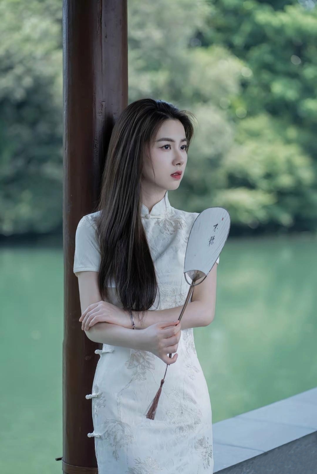 夏日荷花池畔,一袭白衣如画的她,手持团扇,静谧美好.