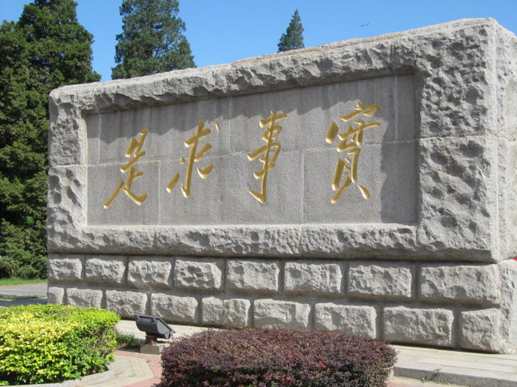 校门口陈放着一块刻有校训"实事求是"的