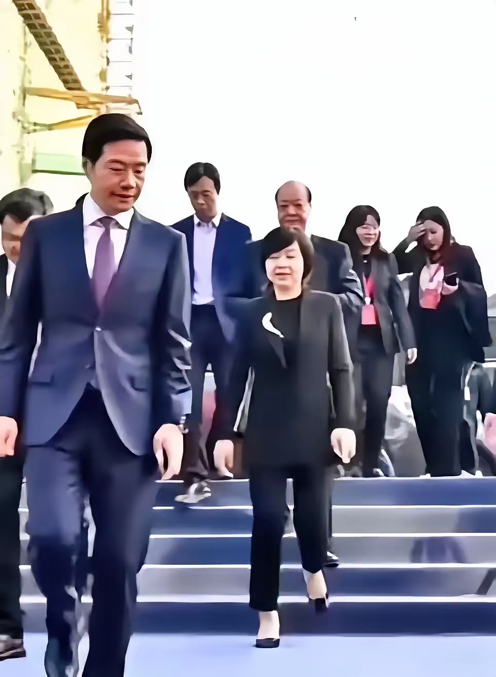 雷军大步走在前面,时不时的扭头回望一下老婆