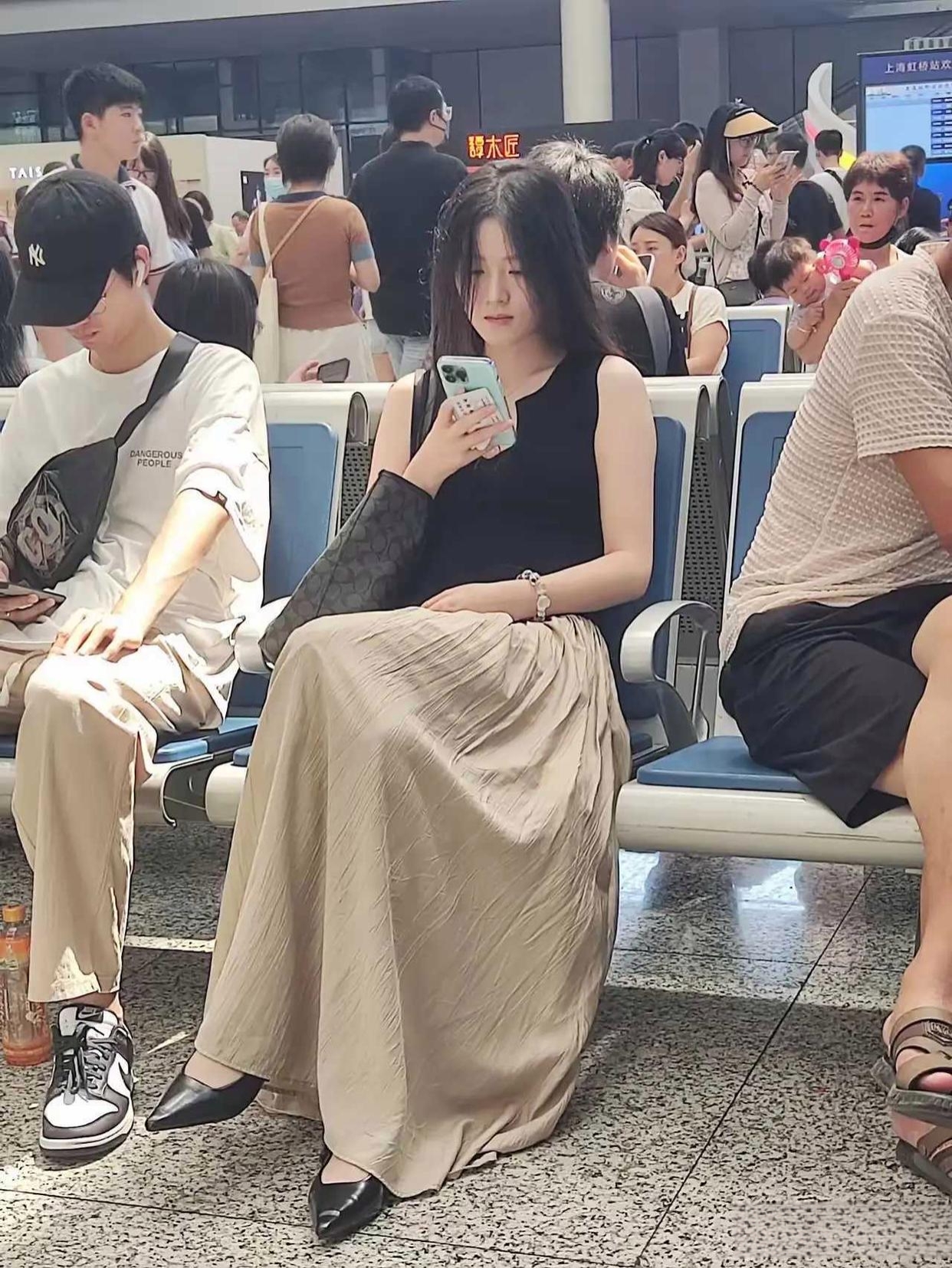 今天在高铁站候车的时候看见坐在对面的一美女,长发飘飘曳地长裙,很有