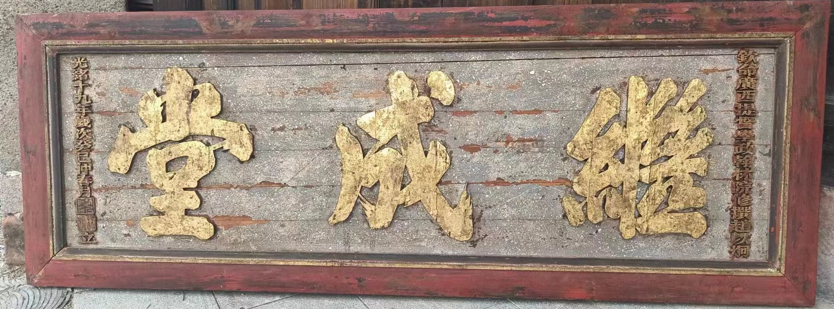此匾金字灰绿底,边框简素,涂以红色