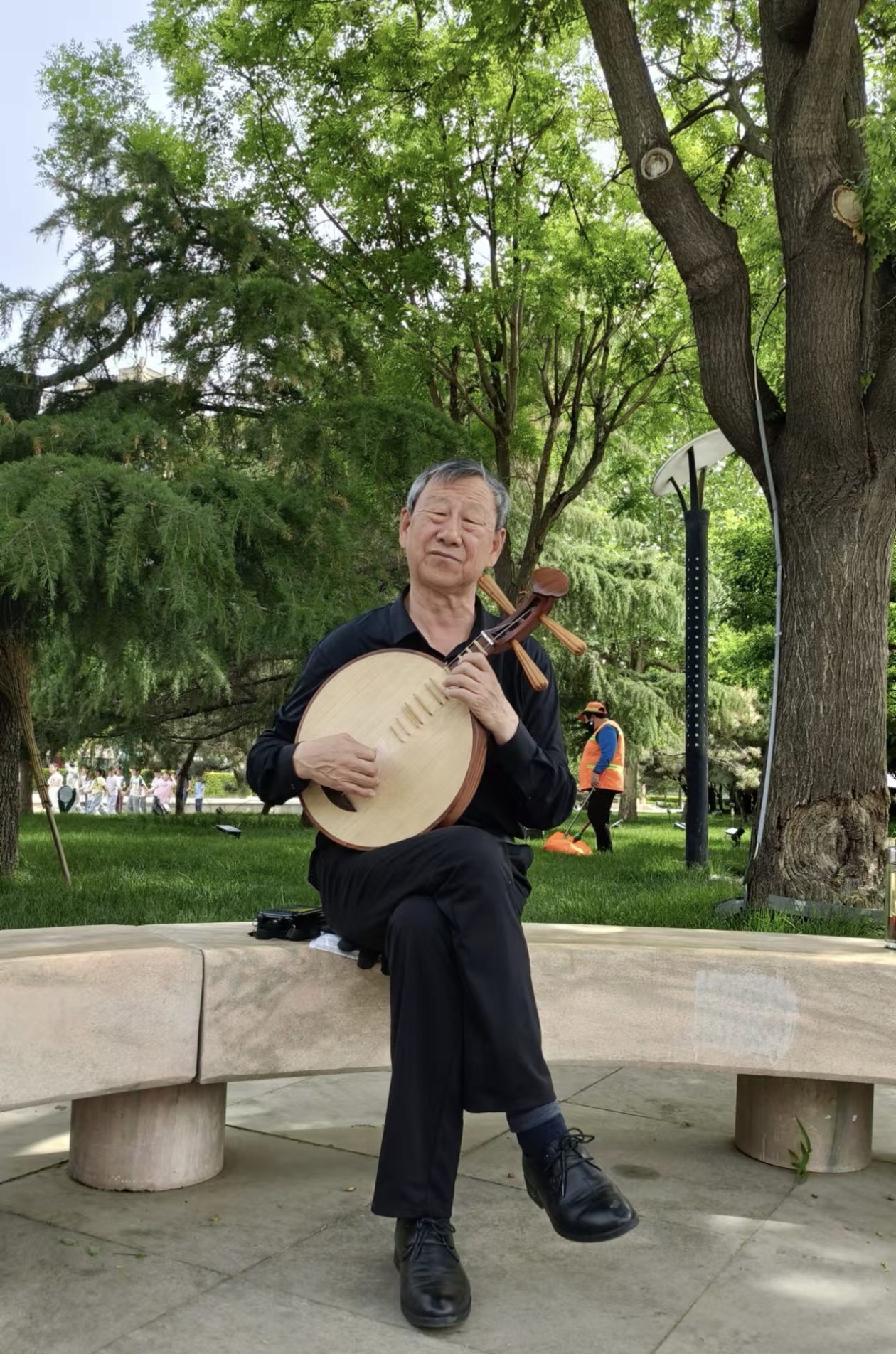 舞台上,一位白发老者怀抱月琴,指尖翻飞如蝶,清越