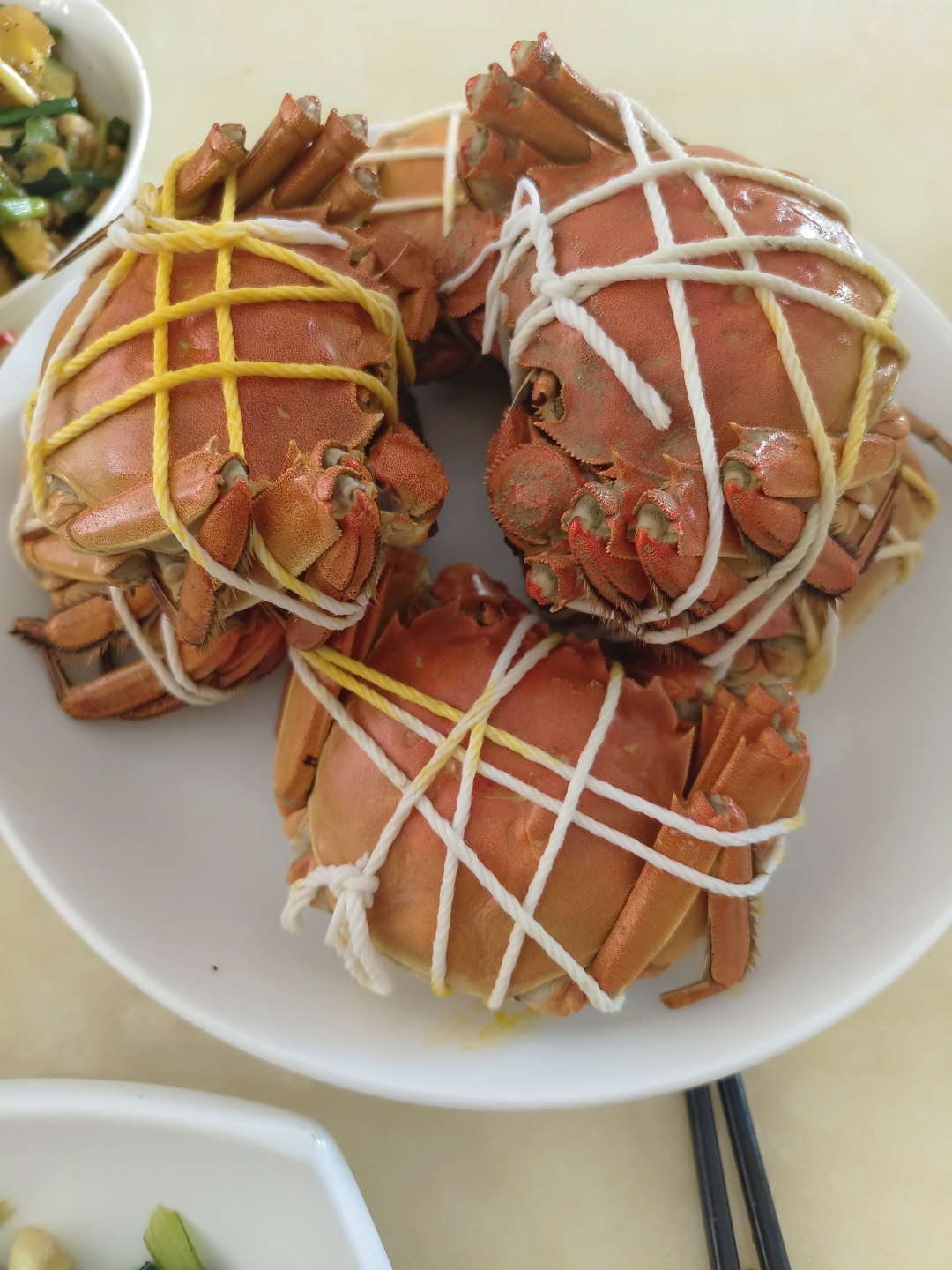 女孩坐在餐桌前,面前是一盘金黄诱人的大闸蟹