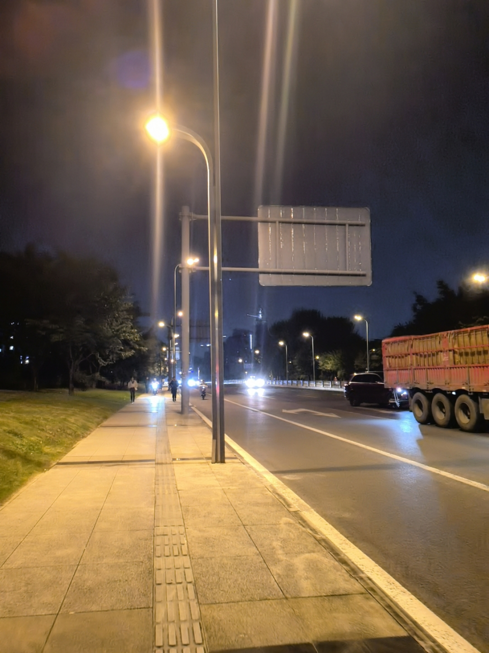 夜晚的城市街道,路灯像星星点点,照亮了道路和人行道