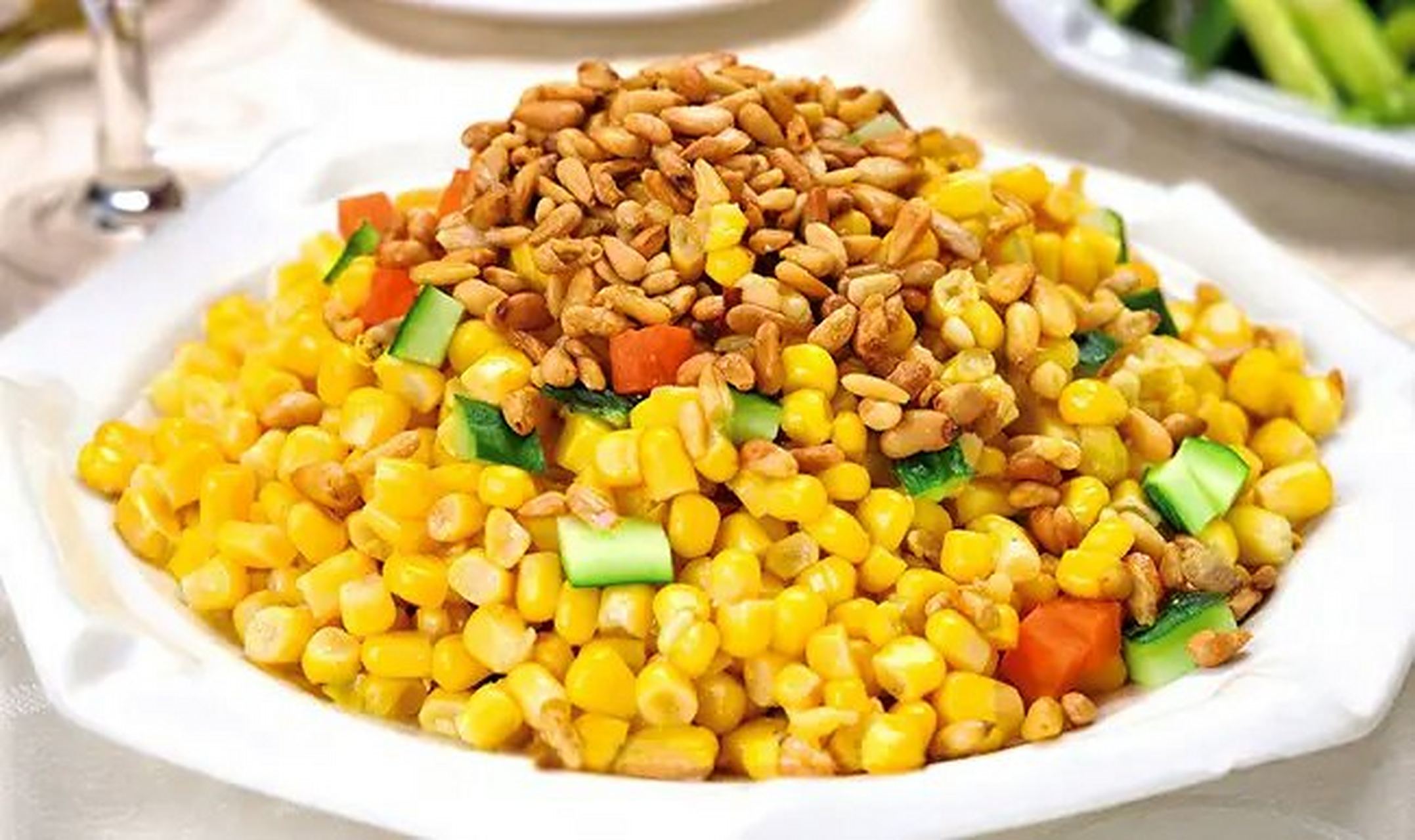 松仁玉米 材料:糯玉米200克,青豆50克,胡萝卜50克,松仁30克,食盐2克