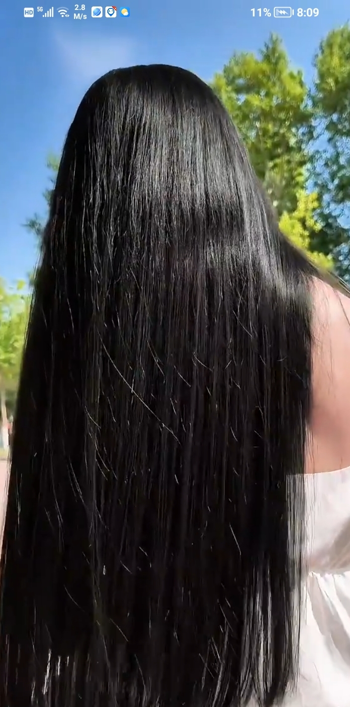 一头瀑布般的黑发,在阳光下更显蓬松轻盈,秀出肩颈线条,女人味十足