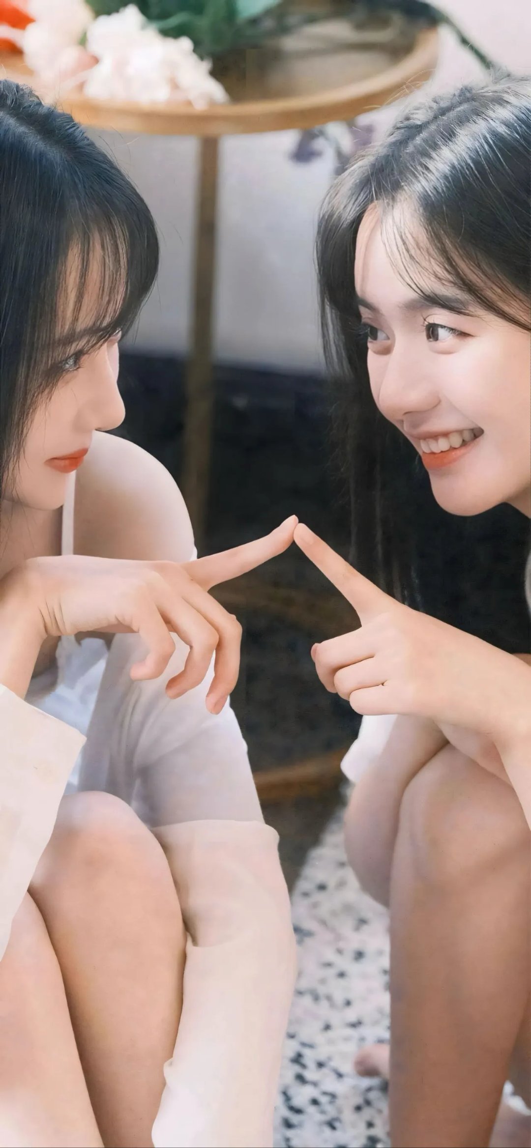 捕捉到一位小姐姐坐在地板上,穿着粉嫩的连衣裙,手