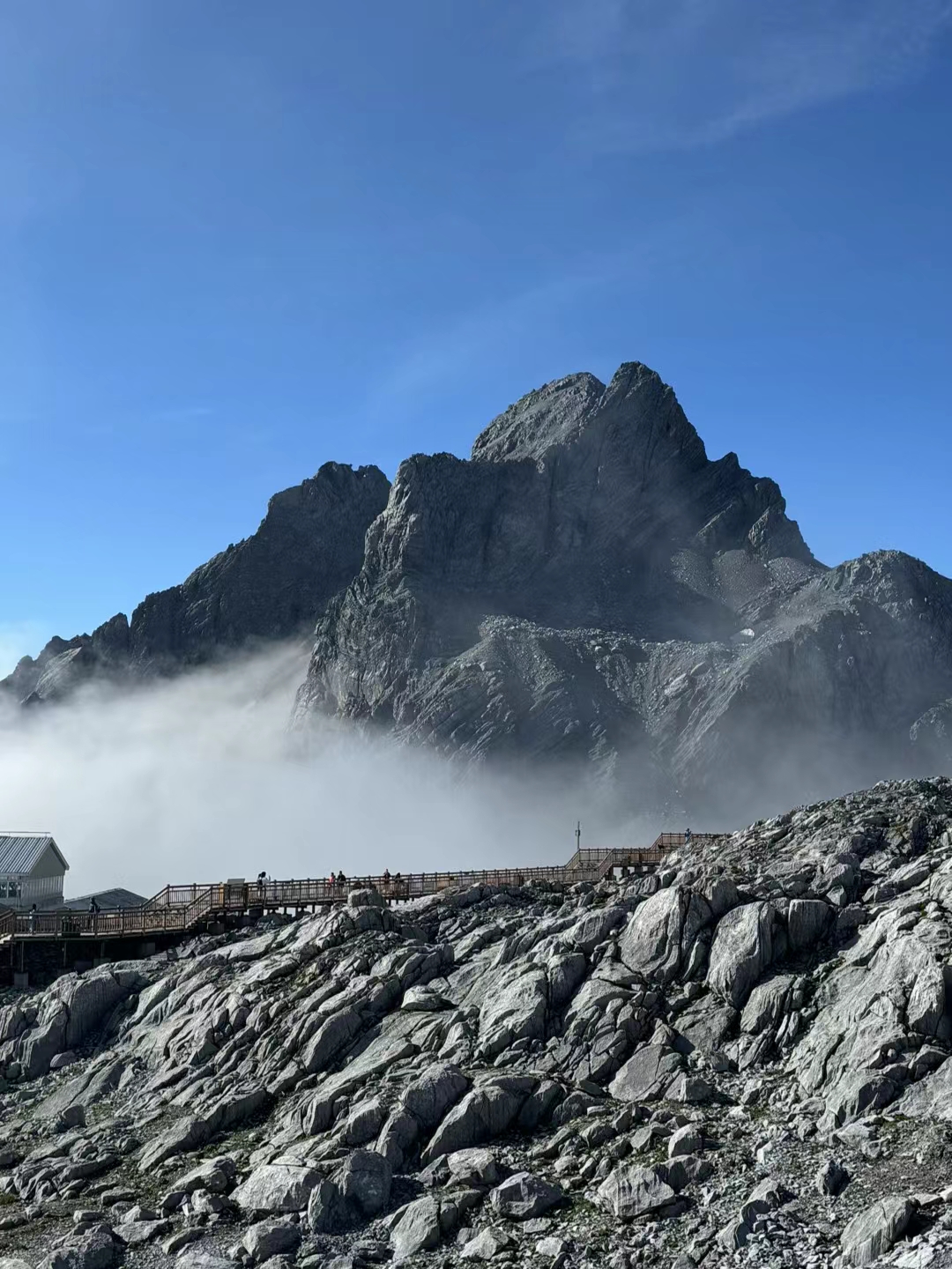 玉龙雪山褪去雪衣,裸露的岩壁如大地脊梁,棱角分明