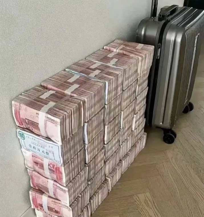 画面中,大量百元人民币整齐堆叠,宛如一座财富的小山