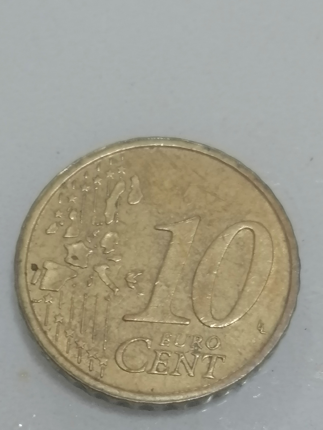 这枚10欧分硬币看起来有些年头了,表面略显磨损,但"euro cent"的字样