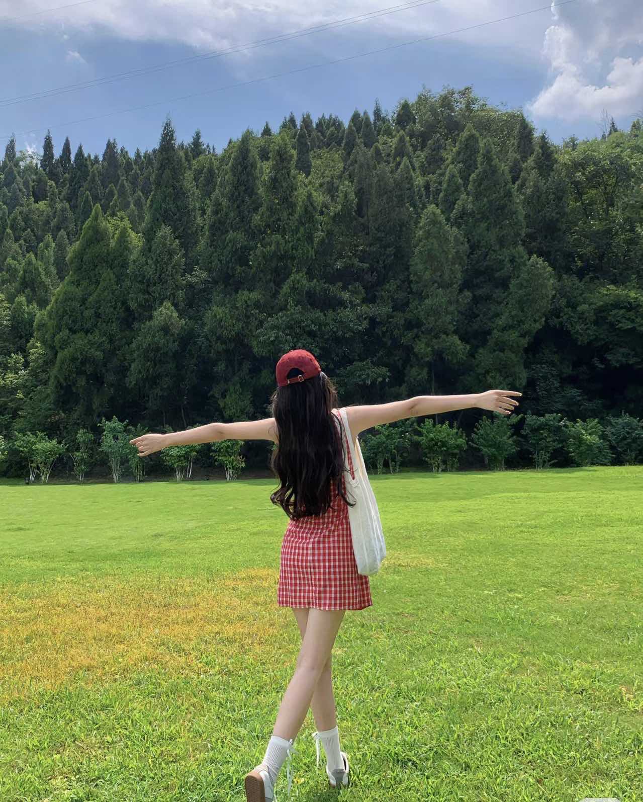 绿茵草地上,女孩张开双臂,拥抱这美好的一天.